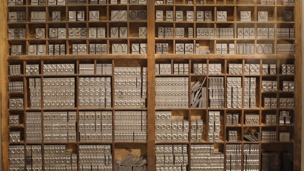 Casse de typographe en bois aux nombreux compartiments remplis de caractères d'imprimerie en plomb, exposée au musée Champollion