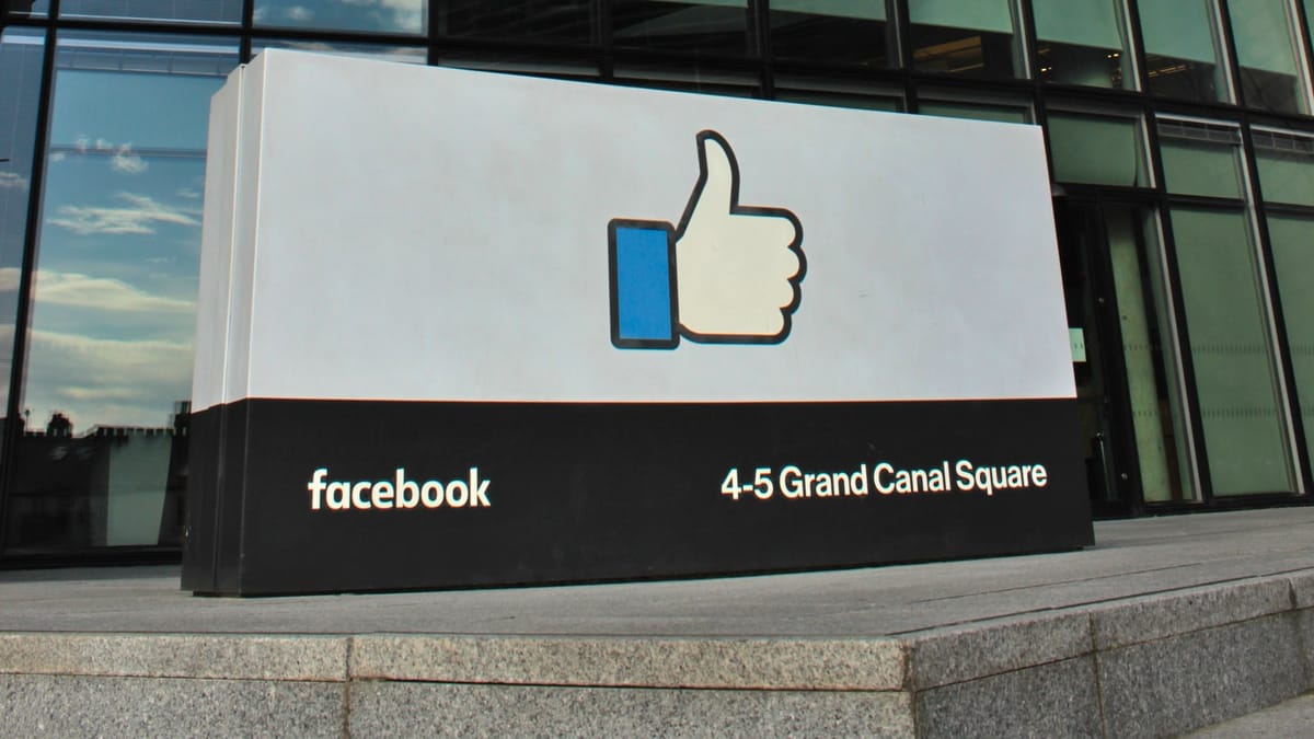 Panneau au logo « J’aime » de Facebook, portant l’adresse 4-5 Grand Canal Square, devant un immeuble de bureaux en verre à Dublin