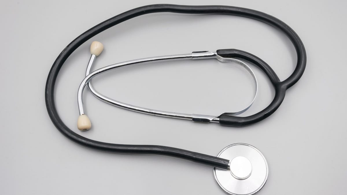 Stéthoscope posé à plat sur un fond uni
